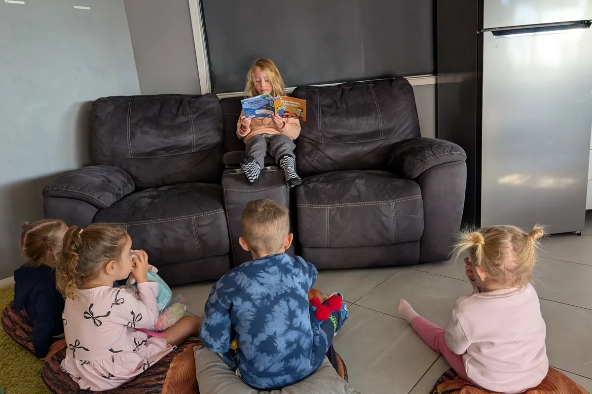 Children sitting on cushions listening to a story being read aloud at Gizmo's in Pacific Pines.